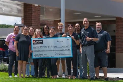 Crew Carwash holding $200k check for Big Brothers Big Sisters.