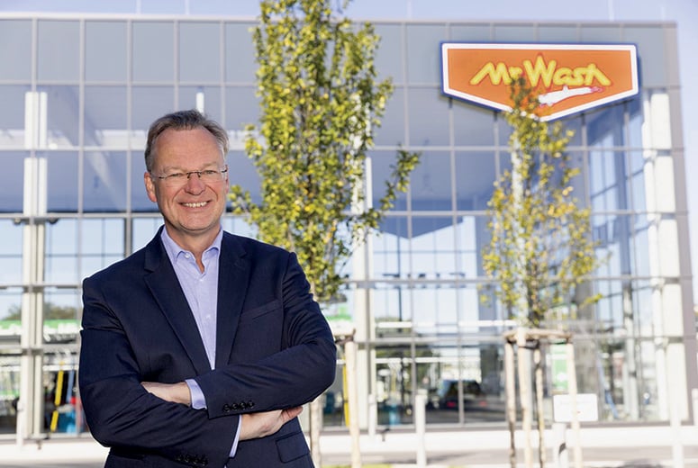 Richard Enning in front of a Mr. Wash location